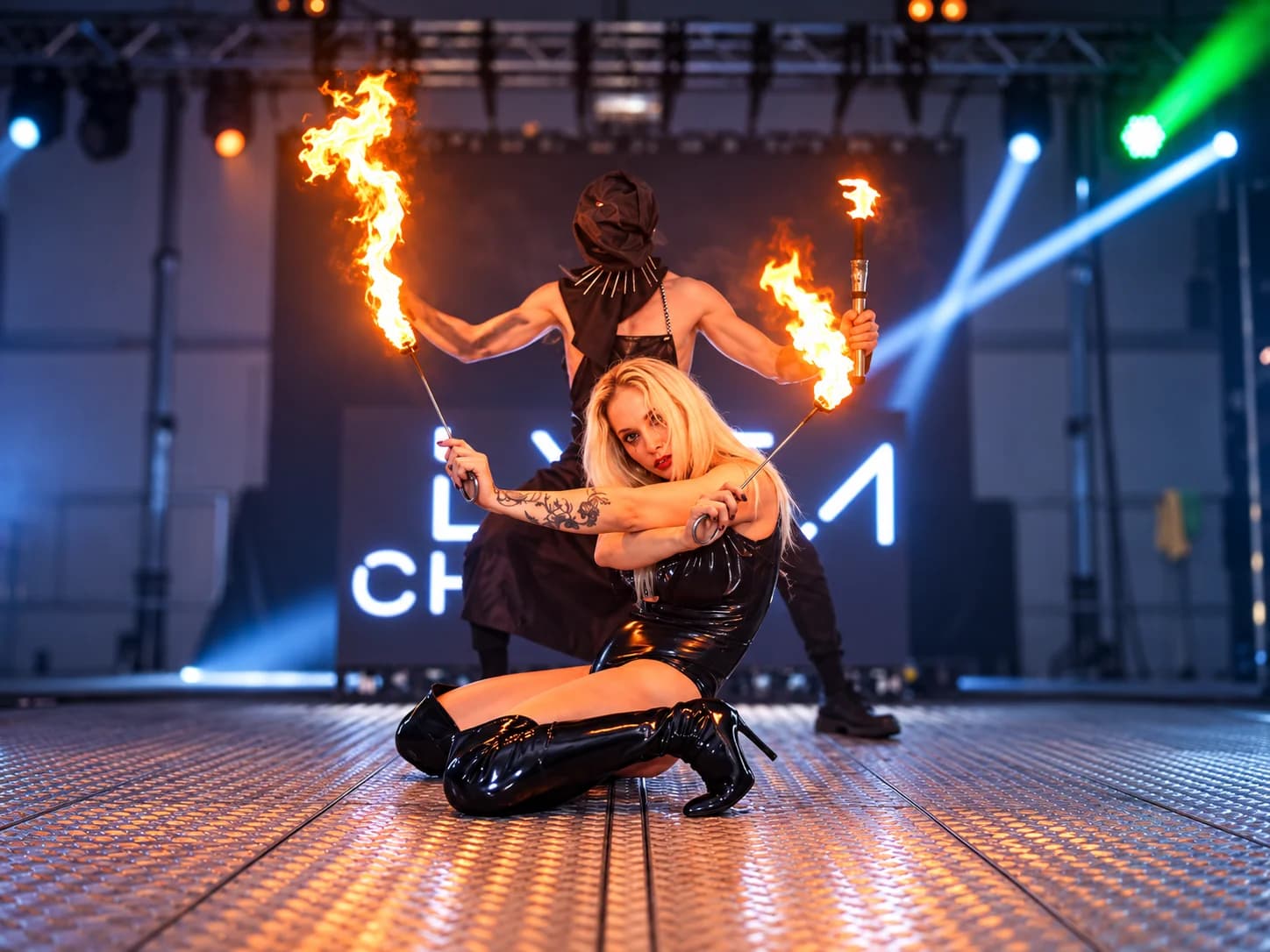 Due performer con il fuoco sul palco illuminato